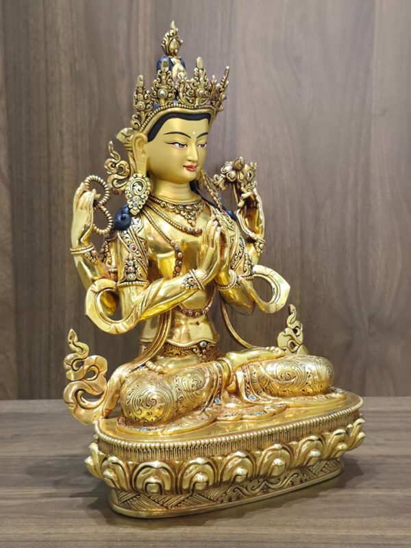 Right-facing view of four-armed Chenrezig statue showing joined hands, prayer beads, lotus and engraved garments.