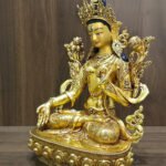 White Tara statue in 24K gold plated copper, left-facing angled view showing the ornate crown, lotus flowers and seated posture.