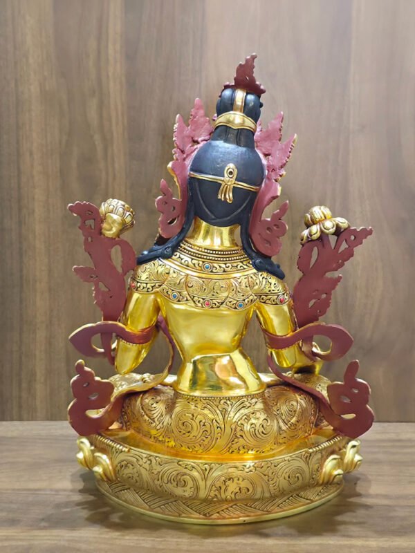 Rear view of the White Tara statue in 24K gold plated copper, showing dark painted hair, patterned garments and the decorated lotus base.