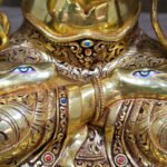 White Tara statue in 24K gold plated copper, close-up of the painted eyes on both soles and intricately patterned garments.